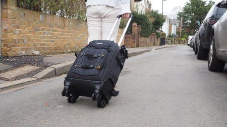 Person pulling a Vanguard Alta Fly 55T G2 on a road