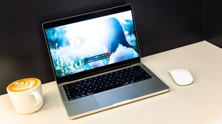 Apple MacBook Pro 14 (M5 Max) on a white table in front of a black wall