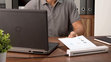 Man feeding a document into one of the best scanners
