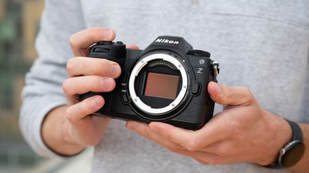 Nikon Z6 III camera held in a pair of hands with the sensor showing