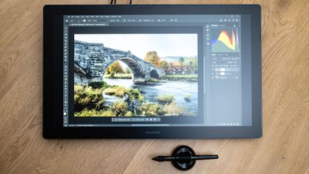 Huion Kamvas 22 Gen 3 and pen on a wooden floor